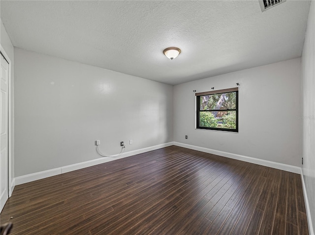 unfurnished room featuring a textured ceiling and dark wood-type flooring