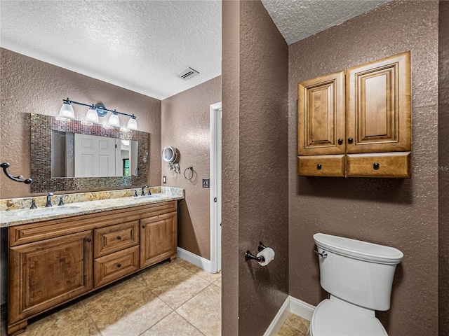 bathroom with tile patterned floors, a textured ceiling, vanity, and toilet