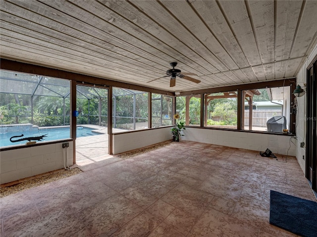 unfurnished sunroom featuring wood ceiling and ceiling fan