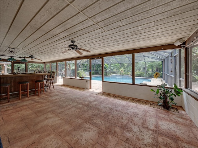 unfurnished sunroom with wood ceiling, indoor bar, and ceiling fan