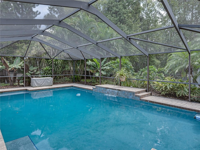 view of swimming pool featuring a lanai