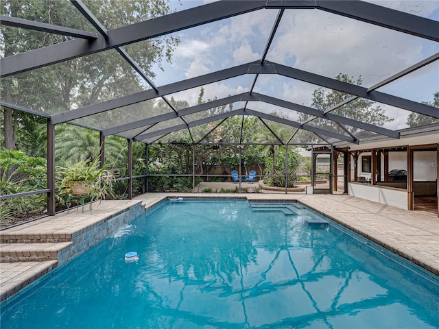 view of swimming pool with a patio and glass enclosure