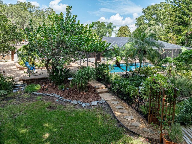 view of yard featuring glass enclosure and a fenced in pool