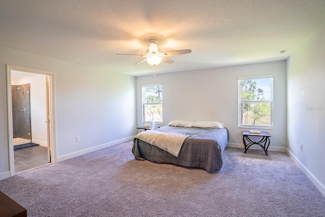 bedroom with ceiling fan, a textured ceiling, ensuite bathroom, and multiple windows