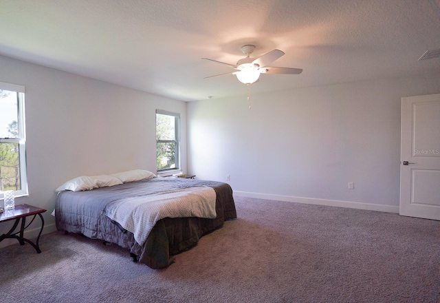 bedroom featuring ceiling fan, carpet flooring, and a textured ceiling