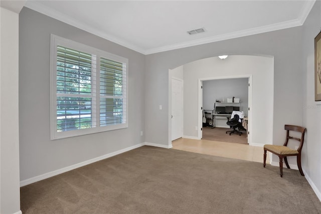 empty room with ornamental molding and light carpet