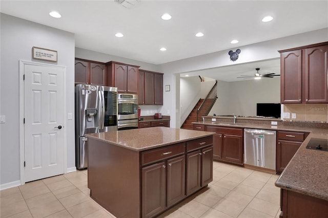 kitchen featuring appliances with stainless steel finishes, a kitchen island, light tile patterned floors, ceiling fan, and sink