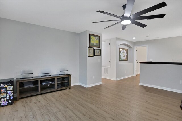 living room with light hardwood / wood-style floors and ceiling fan