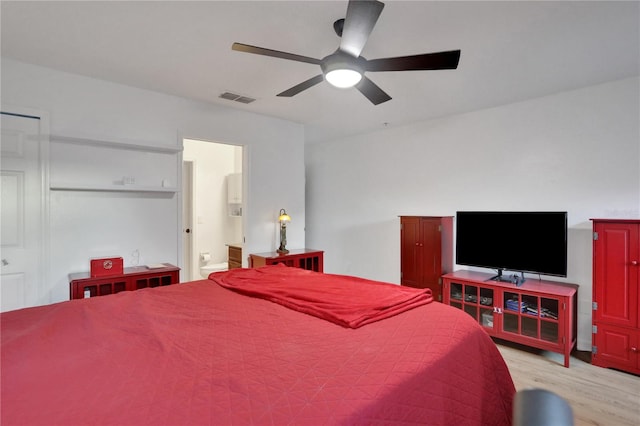 bedroom with ceiling fan, light hardwood / wood-style flooring, and connected bathroom