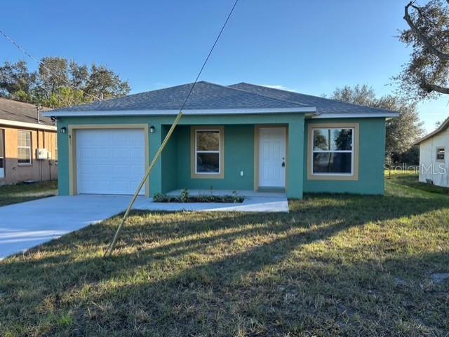 single story home featuring a garage and a front lawn