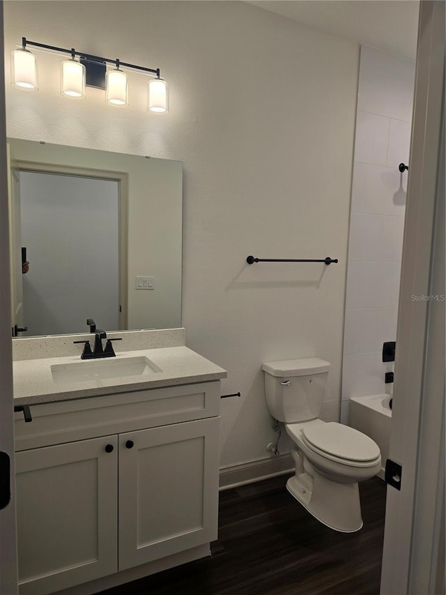 full bathroom with bathtub / shower combination, wood-type flooring, vanity, and toilet