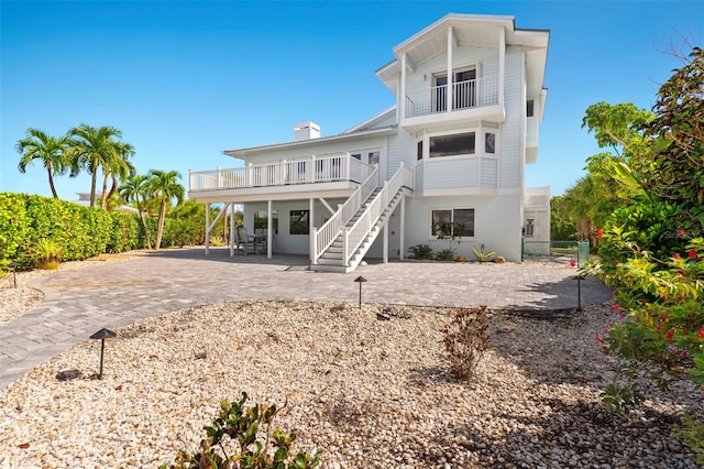 rear view of property featuring a balcony and a patio area