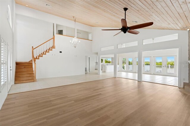 unfurnished living room featuring wood ceiling, light tile patterned flooring, high vaulted ceiling, ceiling fan with notable chandelier, and french doors