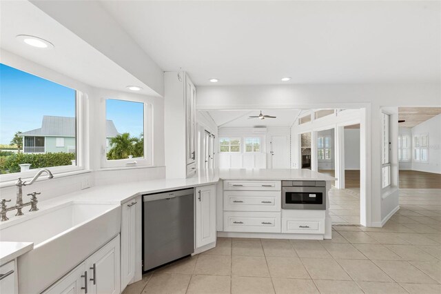 kitchen featuring sink, white cabinets, kitchen peninsula, appliances with stainless steel finishes, and ceiling fan