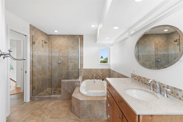 bathroom featuring shower with separate bathtub and vanity