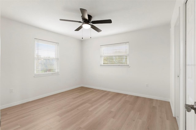 spare room featuring light hardwood / wood-style floors, ceiling fan, and a wealth of natural light