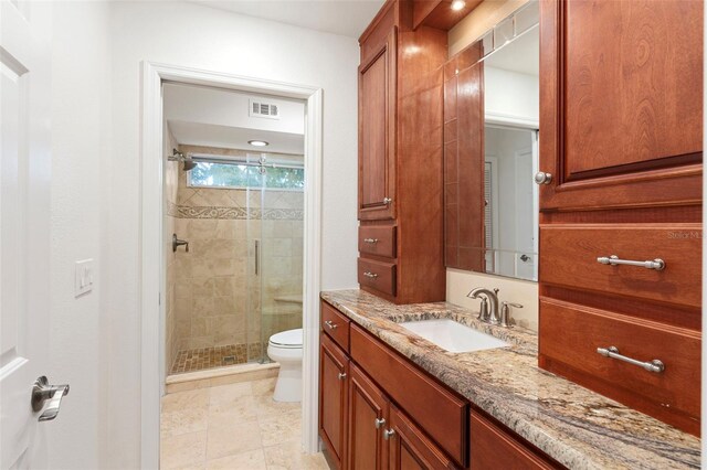 bathroom featuring walk in shower, vanity, toilet, and tile patterned floors