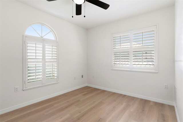 spare room featuring ceiling fan, light hardwood / wood-style floors, and a healthy amount of sunlight