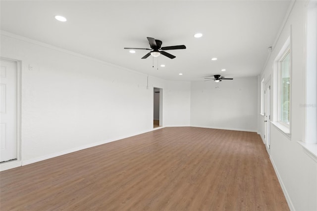 empty room with ceiling fan, crown molding, and hardwood / wood-style floors