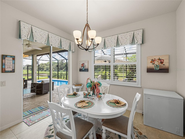 tiled dining area with ceiling fan with notable chandelier and a wealth of natural light