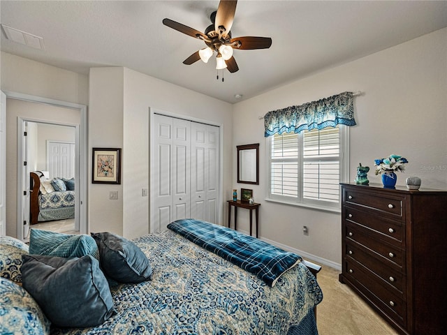 carpeted bedroom featuring ceiling fan and a closet