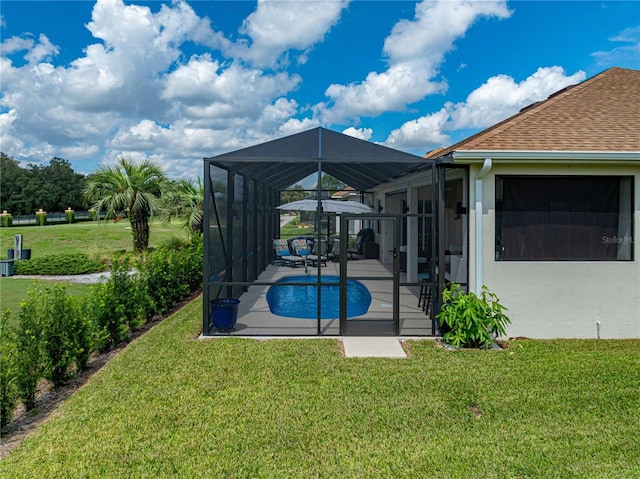 view of pool with glass enclosure, a lawn, and a patio area