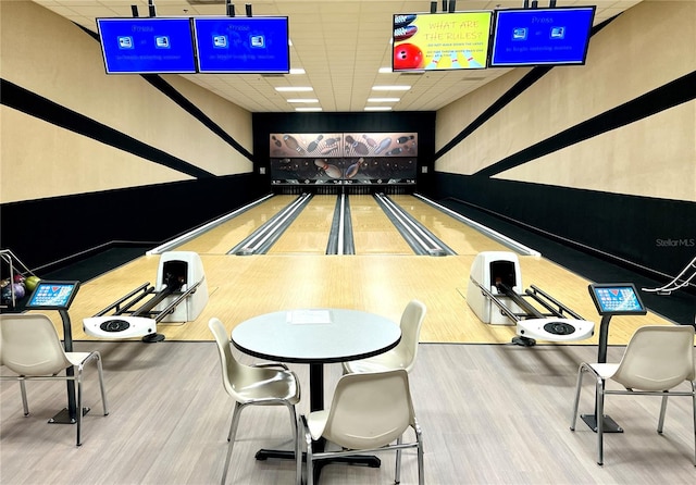 game room with a paneled ceiling and hardwood / wood-style floors