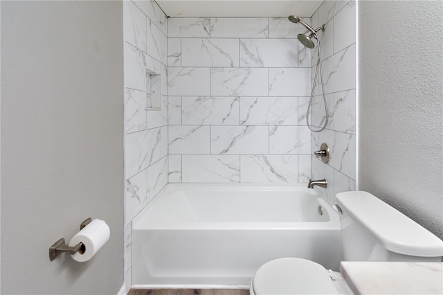 full bathroom featuring tiled shower / bath combo, vanity, and toilet