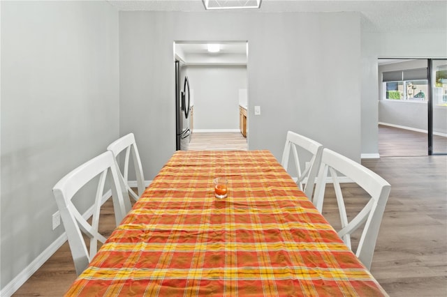 dining room with a textured ceiling and hardwood / wood-style flooring