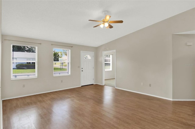 interior space with ceiling fan, vaulted ceiling, and dark wood-type flooring