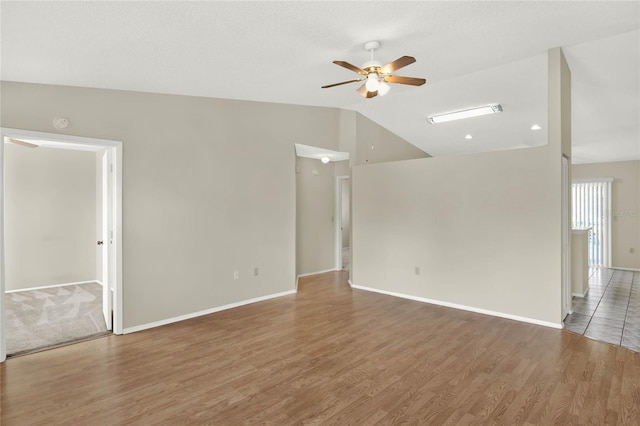 empty room featuring lofted ceiling, ceiling fan, and hardwood / wood-style floors