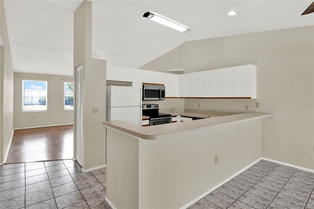 kitchen with light tile patterned flooring, white cabinetry, kitchen peninsula, high vaulted ceiling, and stainless steel appliances