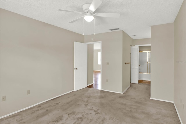 interior space with ceiling fan, light colored carpet, and a textured ceiling