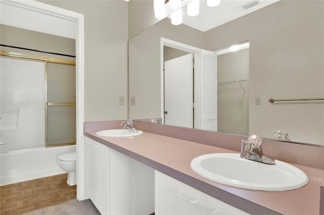 full bathroom with parquet flooring, shower / bath combination with glass door, vanity, and toilet