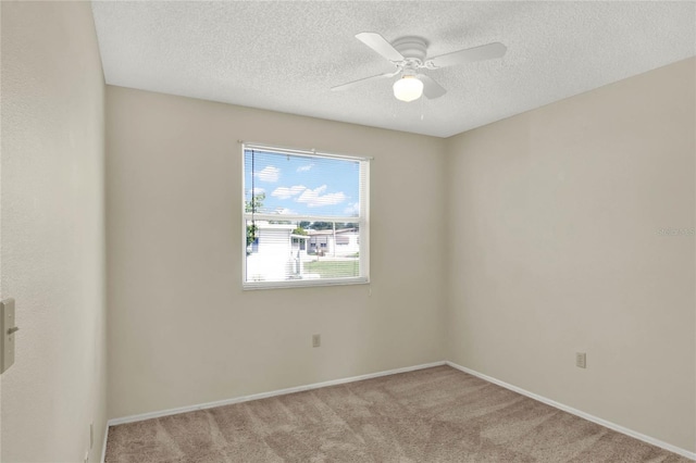 carpeted empty room featuring a textured ceiling and ceiling fan