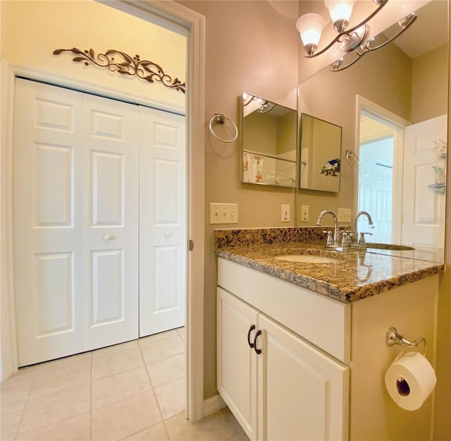 bathroom with tile patterned flooring, vanity, and a chandelier