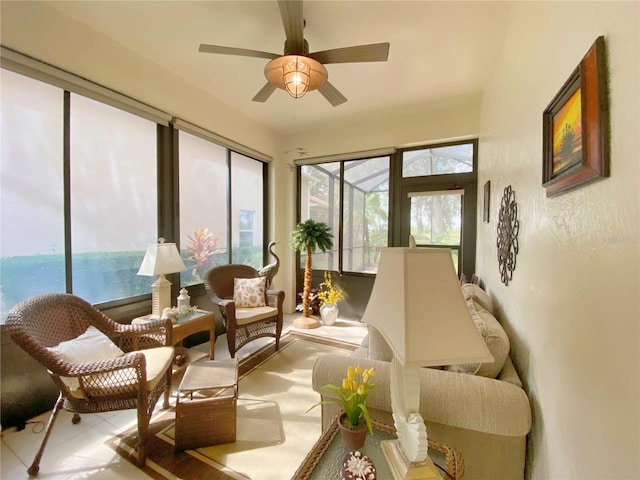 sunroom featuring ceiling fan and a water view