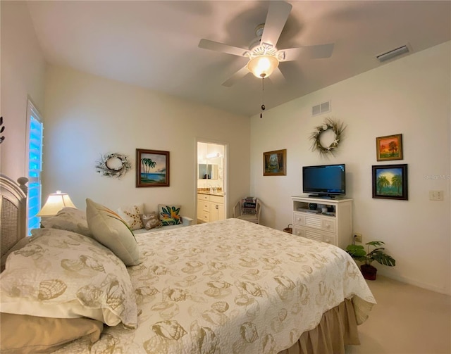 carpeted bedroom with ensuite bathroom and ceiling fan