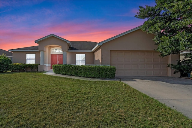 ranch-style house featuring a garage and a lawn