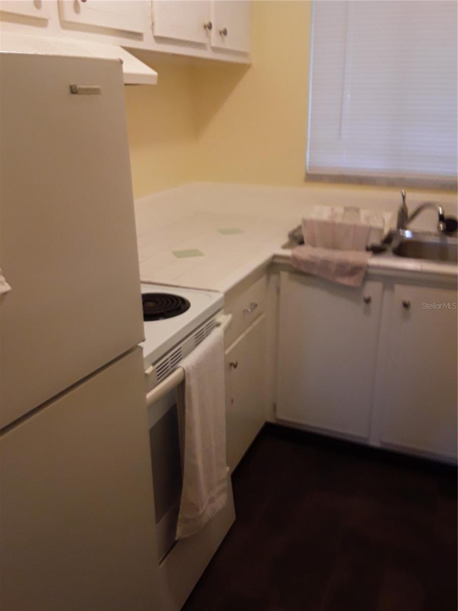 kitchen featuring white cabinets, sink, and white appliances