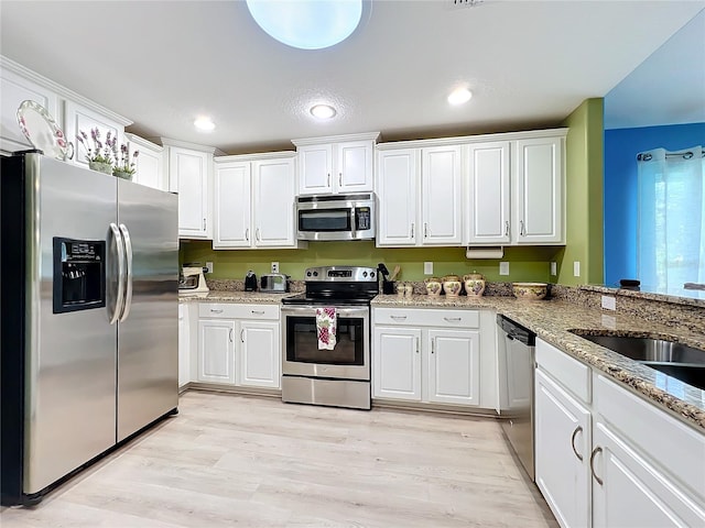 kitchen with white cabinetry, light hardwood / wood-style floors, and appliances with stainless steel finishes