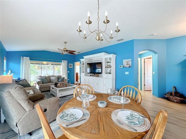 dining area featuring ceiling fan with notable chandelier, lofted ceiling, and light hardwood / wood-style flooring