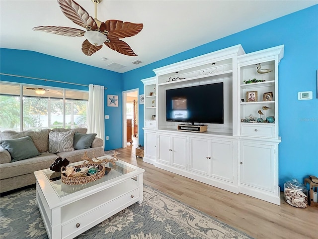 living room featuring ceiling fan, light hardwood / wood-style flooring, and lofted ceiling