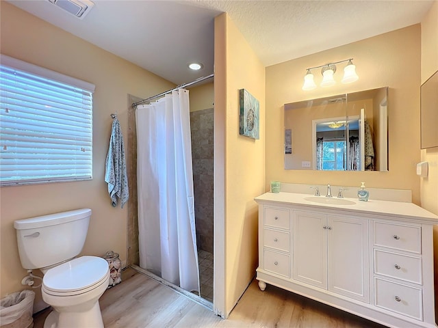 bathroom featuring curtained shower, hardwood / wood-style floors, vanity, and toilet