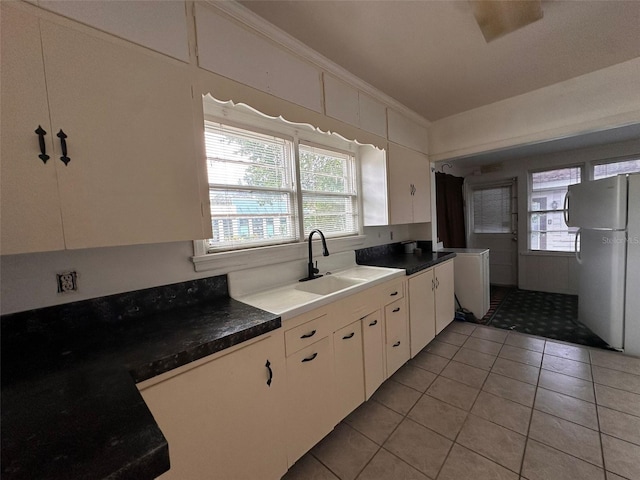 121 Bates Ave SE, Winter Haven, FL 33880 - kitchen featuring stainless steel fridge, light tile patterned flooring, white cabinetry, ornamental molding, and sink