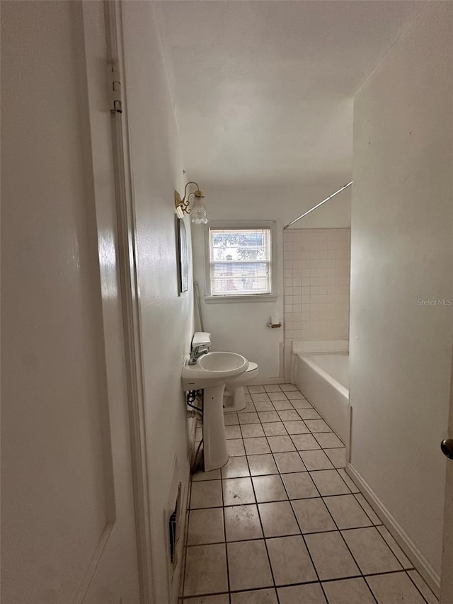 121 Bates Ave SE, Winter Haven, FL 33880 - bathroom featuring tiled shower / bath, toilet, and tile patterned floors