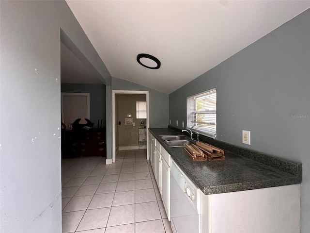 121 Bates Ave SE, Winter Haven, FL 33880 - kitchen with lofted ceiling, light tile patterned floors, sink, white cabinetry, and dishwasher