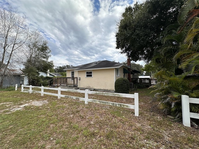 121 Bates Ave SE, Winter Haven, FL 33880 - view of home's exterior with a lawn and a wooden deck