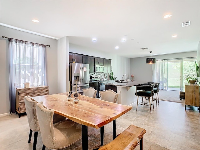 dining space featuring a wealth of natural light and sink