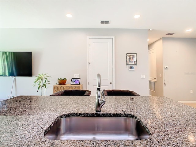 kitchen with light stone countertops and sink